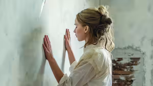 Mother (Jennifer Lawrence) presses both hands against a wall inside the house