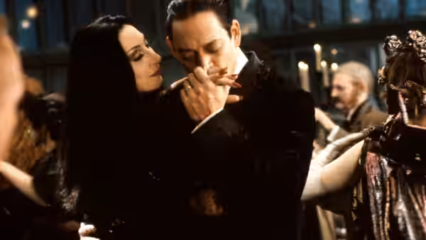 Morticia Addams (Anjelica Huston) and Gomez Addams (Raul Julia) embrace in a candlelit ballroom