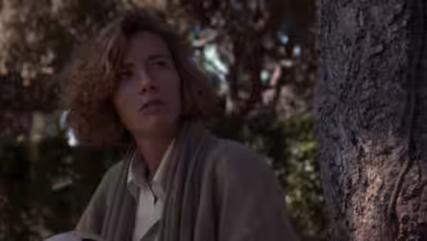 Grace (Emma Thompson) sitting outdoors against a tree and looking upward