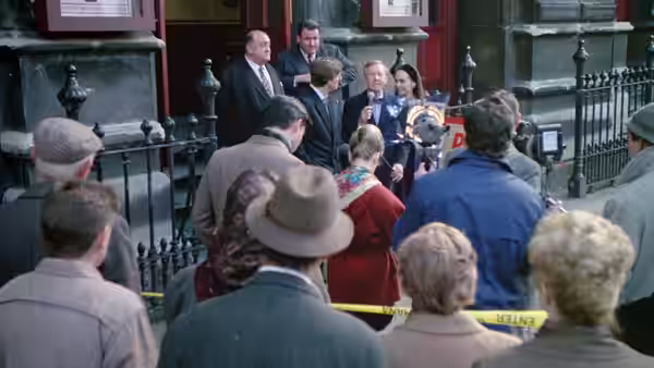 A crowd gathered outside a building watching musicians perform