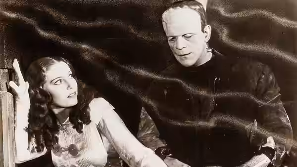 Elizabeth (Valerie Hobson) looks upward as the Monster looms behind her