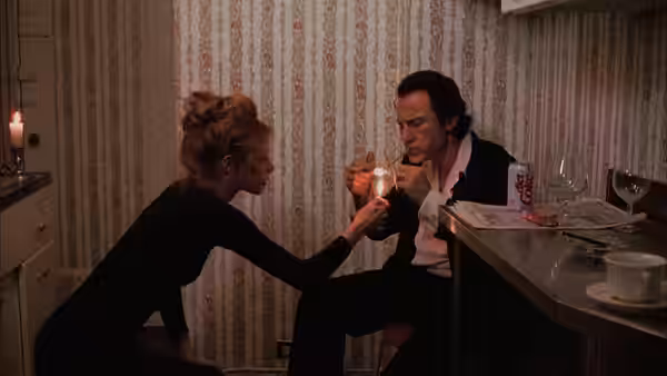 LT (Harvey Keitel) leaning over a table to use cocaine with a woman