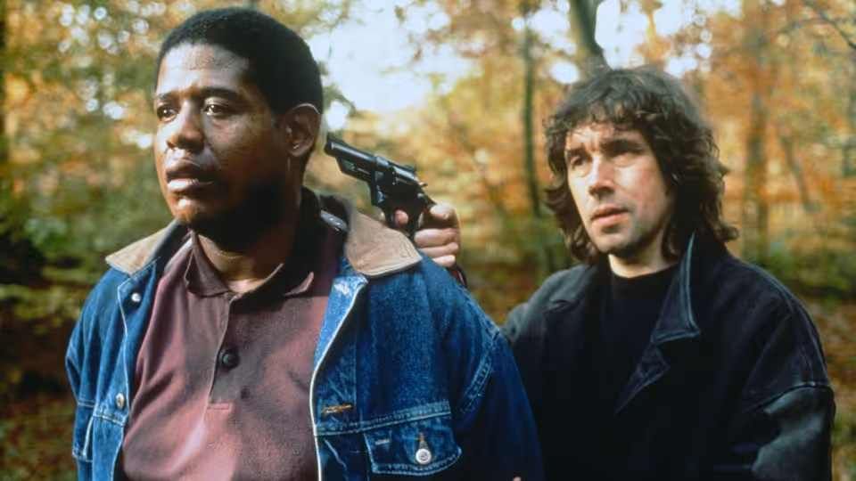 Jody (Forest Whitaker) with gun held to his head by Fergus (Stephen Rea) in woods