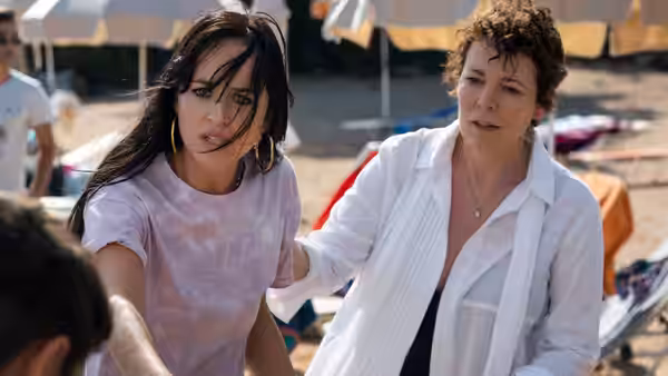 Nina (Dakota Johnson) and Leda (Olivia Colman) stand together on the beach