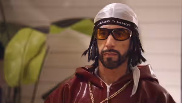 Ali G (Sacha Baron Cohen) wears amber sunglasses and a white beanie indoors