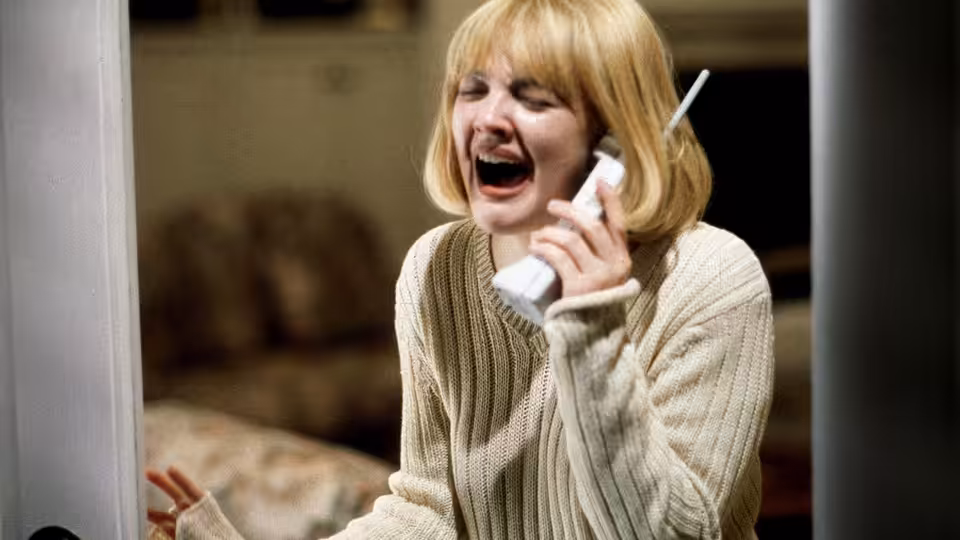 Casey (Drew Barrymore) screaming into a telephone receiver at home