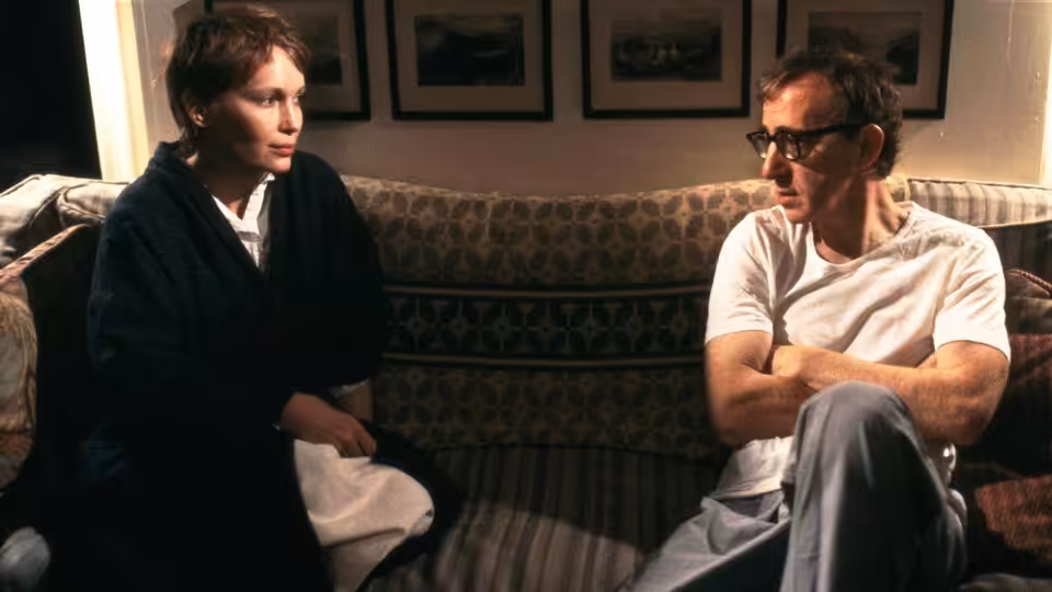 Sally (Judy Davis) and Gabe (Woody Allen) seated facing each other on a couch