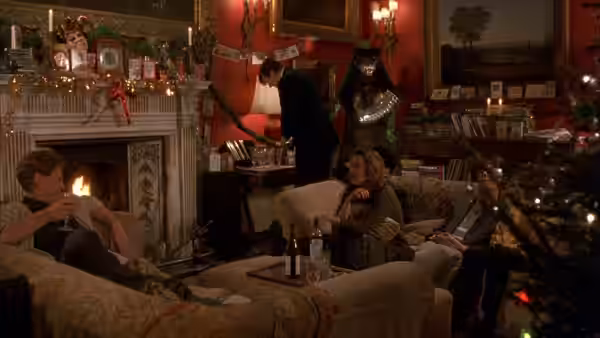 People relaxing on sofas in a red living room with fireplace and Christmas tree