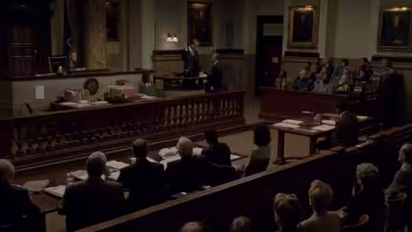 Lawyers addressing the judge in a formal courtroom with spectators seated