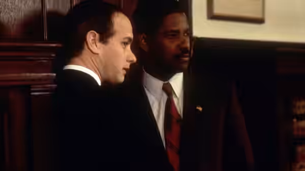Two suited men standing together in a wood-panelled office interior
