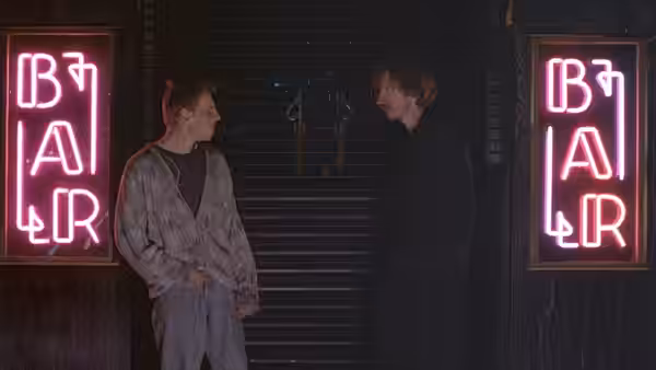 Archie (Ewen Bremner) talking to Johnny (David Thewlis) outside neon bar signs