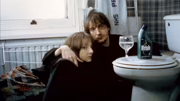Johnny (David Thewlis) with arm around Louise (Lesley Sharp) on bathroom floor