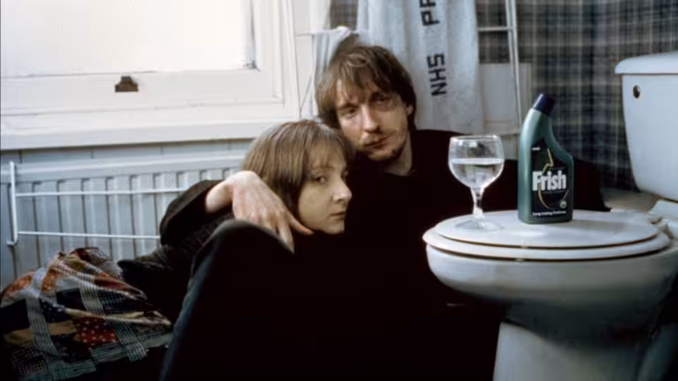 Johnny (David Thewlis) with arm around Louise (Lesley Sharp) on bathroom floor