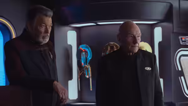 Jean-Luc Picard (Patrick Stewart) and William Riker stand together inside a starship