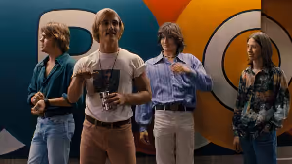 Wooderson (Matthew McConaughey) standing with three friends in front of a colorful wall