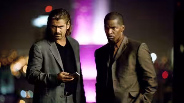 Sonny Crockett (Colin Farrell) and Rico Tubbs (Jamie Foxx) stand amid neon-lit city streets