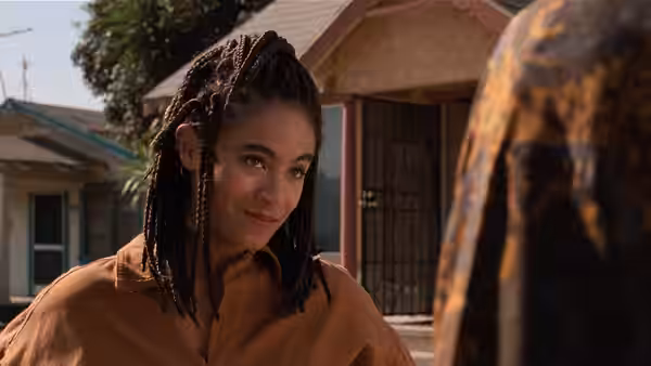 Ronnie (Jada Pinkett Smith) stands outside a house looking to the side