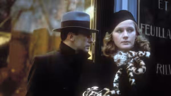 A man and woman stand close together outside at night