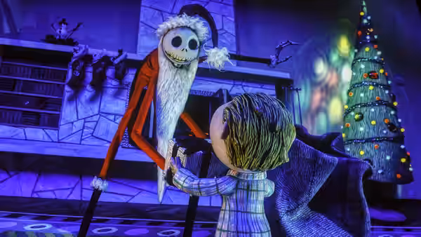 Jack Skellington in a Santa suit handing a gift to a boy