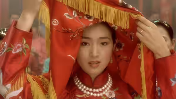 Juxian (Gong Li) lifting a red veil over her head