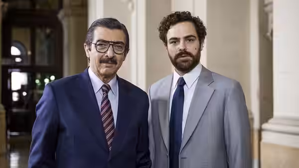 Julio Strassera (Ricardo Darín) and Luis Moreno Ocampo (Peter Lanzani) stand together in a courthouse corridor