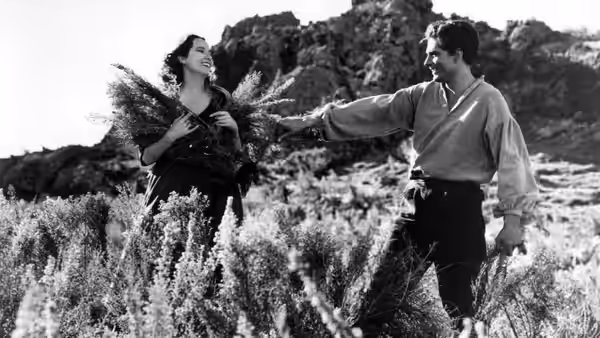 Cathy (Merle Oberon) holding branches beside Heathcliff (Laurence Olivier) on the moors