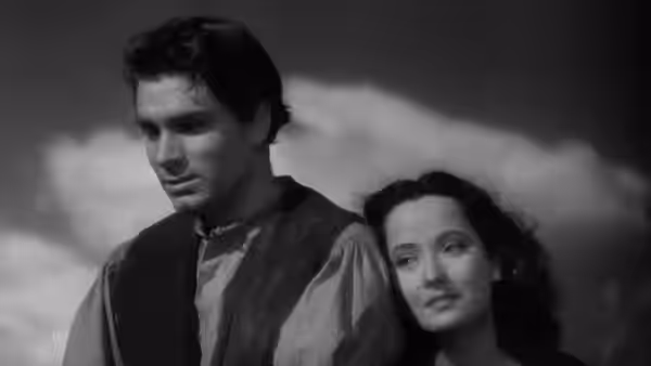 Heathcliff (Laurence Olivier) and Cathy (Merle Oberon) standing close together outdoors