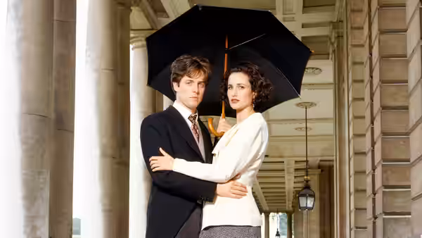 Charles (Hugh Grant) and Carrie (Andie MacDowell) huddle beneath a black umbrella
