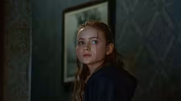 Ellie (Sadie Sink) looks back inside the apartment