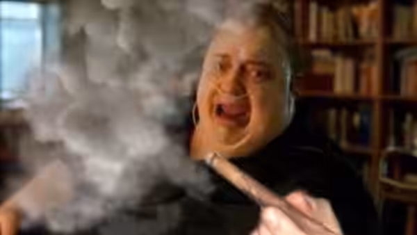 Charlie (Brendan Fraser) laughs while holding a smoking joint in his apartment