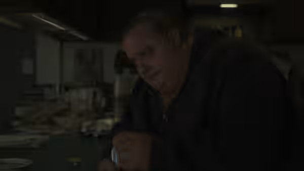 Charlie (Brendan Fraser) leans over a kitchen counter in his apartment