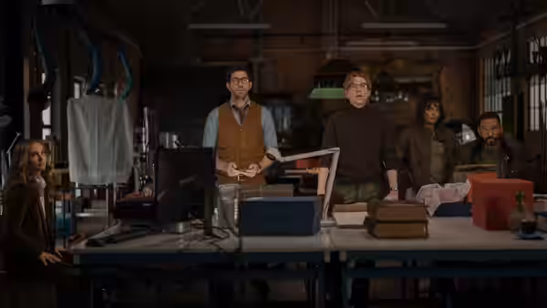 A group gathers around a cluttered workbench in a crowded workshop