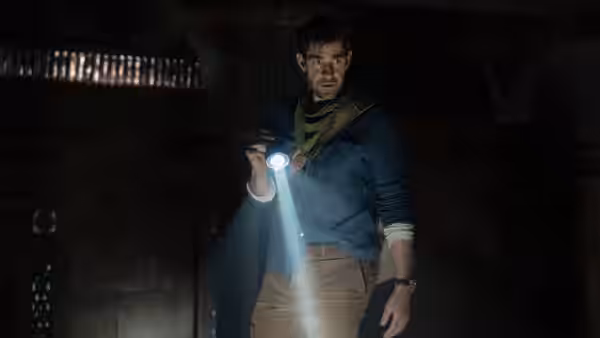 Luke Purdue searches a dark stone chamber with a flashlight
