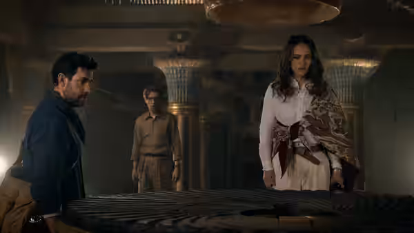 Luke Purdue and Charlotte Purdue examine a circular stone table as Owen watches inside a temple