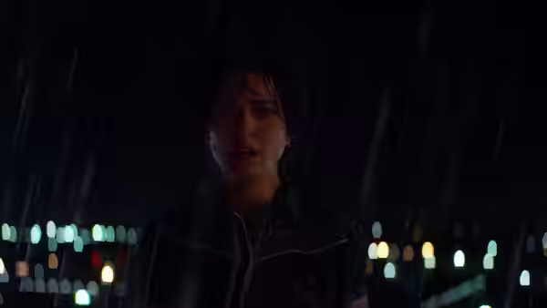 Lucy Cola (Natalie Portman) stands in the rain beneath distant lights