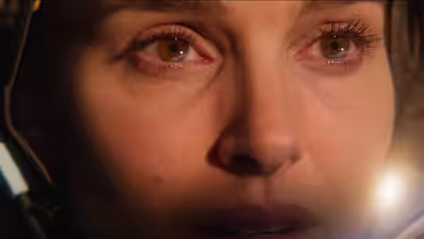 Lucy Cola (Natalie Portman) stares ahead wearing an astronaut helmet