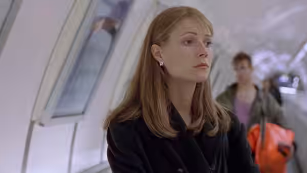 Helen Quilley (Gwyneth Paltrow) waits in an underground station as commuters pass behind her