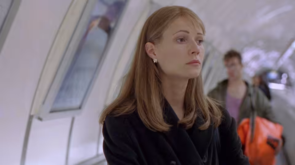 Helen Quilley (Gwyneth Paltrow) waits in an underground station as commuters pass behind her