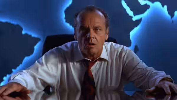 President Dale (Jack Nicholson) leans forward at a control console