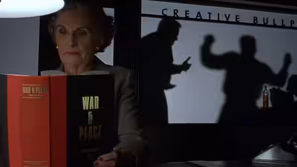 Elderly woman holding War and Peace with shadows projected on the screen behind