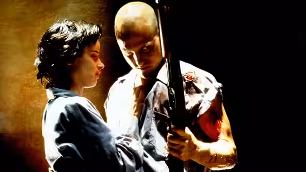 Mallory Knox (Juliette Lewis) beside Mickey Knox (Woody Harrelson) holding a rifle