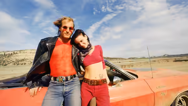 Mickey Knox (Woody Harrelson) and Mallory Knox (Juliette Lewis) by red car in desert