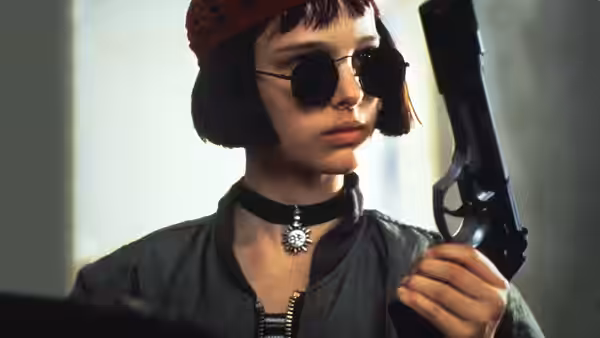 Mathilda (Natalie Portman) wearing sunglasses and holding a handgun