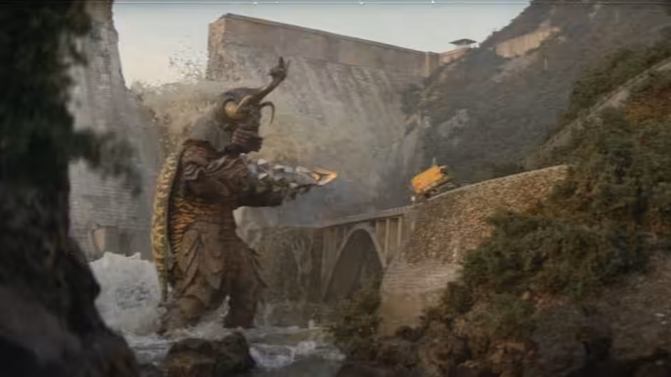 Megalon stands in a rocky ravine beside a stone bridge as debris falls