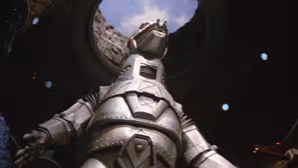 Mechagodzilla stands beneath a circular opening in a dark hangar