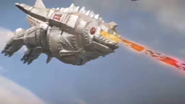 The silver, spiked flying saucer streaks across the sky, firing a red beam