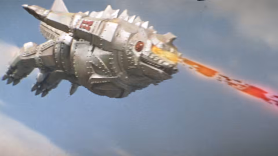 The silver, spiked flying saucer streaks across the sky, firing a red beam