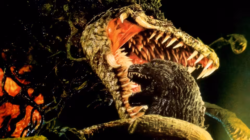 Godzilla struggles beneath Biollante’s open jaws and jagged teeth