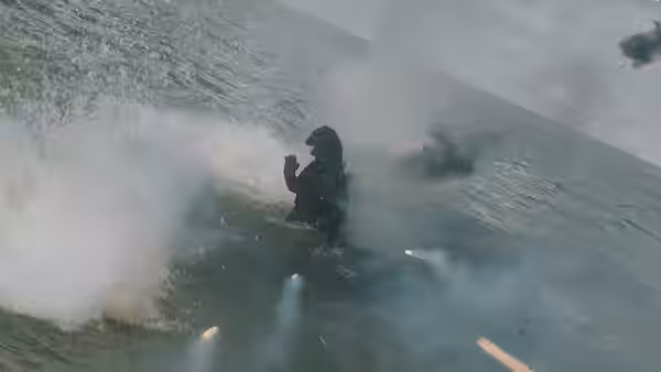 A lone figure stands in shallow water as explosions erupt nearby