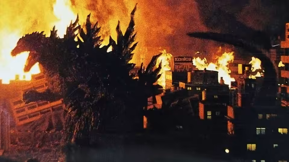 Godzilla towers over buildings engulfed in flames